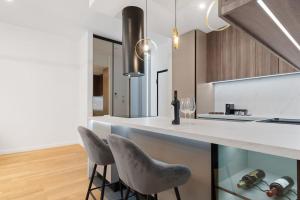 una cucina con un bancone e due sgabelli di Business Panorama Loft 5star Location, Queen Beds a Bucarest