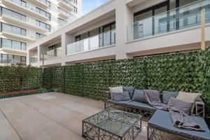 un patio con divano e tavoli di fronte a un edificio di Business Panorama Loft 5star Location, Queen Beds a Bucarest