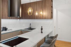 una cucina con lavello e mobili in legno di Business Panorama Loft 5star Location, Queen Beds a Bucarest Altre 28 foto