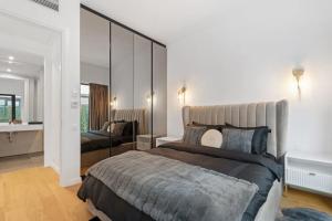 una camera da letto con un letto grande con un grande specchio di Business Panorama Loft 5star Location, Queen Beds a Bucarest