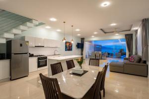 a kitchen and living room with a table and chairs at Sunset Lagoon Villa Rihanna in Bangrak Beach