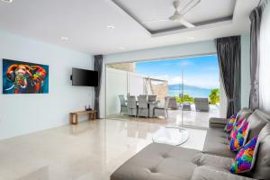 a living room with a couch and a view of the ocean at Sunset Lagoon Villa Rihanna in Bangrak Beach
