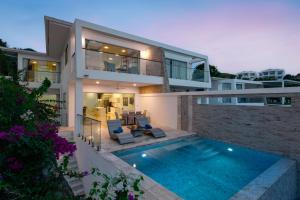 a house with a swimming pool in front of it at Sunset Lagoon Villa Rihanna in Bangrak Beach