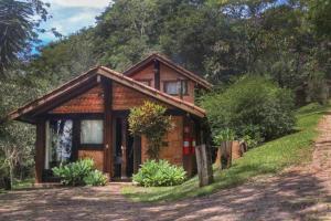 a small wooden house on the side of a hill at Smart Hotel Reserva Santo Antônio do Pinhal in Santo Antônio do Pinhal
