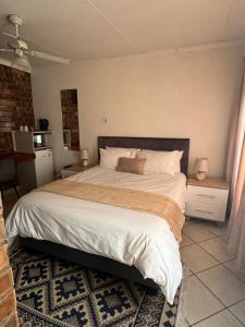 a bedroom with a large bed in a room at Tranquilo Guesthouse in Ermelo
