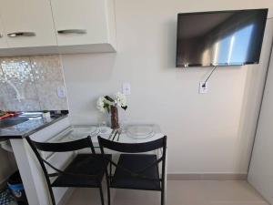 a kitchen with a small table with two chairs at Kitnet303 centro, c linda vista janela, tv smart in Montes Claros