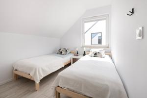 ルミアにあるNAP Apartments Jachtowa Pod Lasemの窓のある白い部屋にベッドが2つある