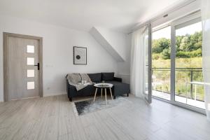 ルミアにあるNAP Apartments Jachtowa Pod Lasemのソファとテーブルのあるリビングルーム