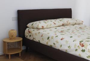 a bed with a blanket and a night stand next to it at Bellapulia apartments in Molfetta