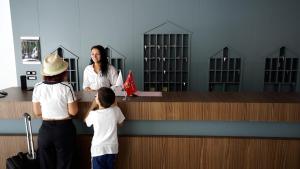 two children and a woman standing at an airport counter at Inheritor Resort in Lezhë +51 photos