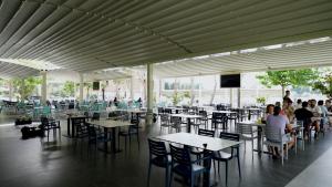 a group of people sitting at tables in a restaurant at Inheritor Resort in Lezhë