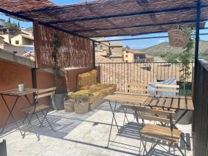 a patio with a couch and tables and chairs at Apartamentos Nomad Home in Huerta de Vero