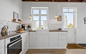 a kitchen with white cabinets and a window at Two-Bedroom Holiday Home In Ringkobing in Ringkøbing