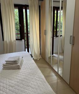 a bedroom with a white bed and a mirror at House Pravilovic apartments in Cetinje