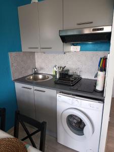 a kitchen with a washing machine and a sink at Appartement au Cap d'Agde in Cap d'Agde +13 photos