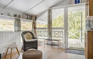 a living room with a chair and a large window at Tziki in Fanø