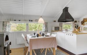 a kitchen with white cabinets and a table with chairs at Tziki in Fanø