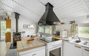 a kitchen with a stove top oven next to a sink at Tziki in Fanø +10 photos