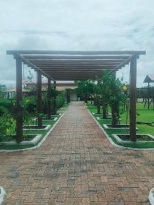 a brick walkway with a pavilion in a park at Cantinho do Abaís, Condominio Meridiem Praia Mar in Praia Da Caueira