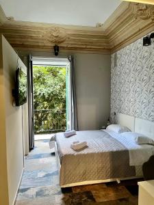 um quarto com uma cama e uma janela grande em B&B Dimora Emily em Palermo