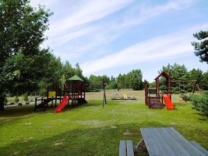 park z placem zabaw ze zjeżdżalniami i ławką w obiekcie Zajazd u Hermanów w mieście Olsztyn