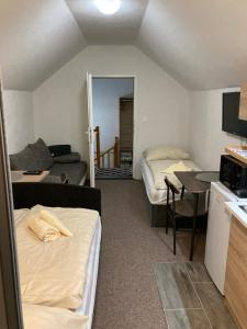 a room with two beds and a kitchen and a living room at Studio Manzarda in Liptovský Mikuláš