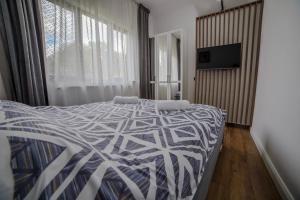 a bedroom with a bed with a blue and white comforter at AcAsA in Turda