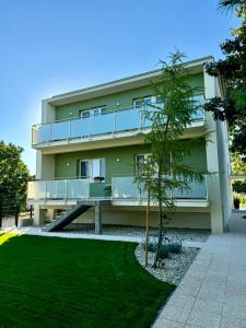 a building with a tree in front of it at Apartment ZOi in Šamorín