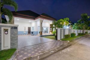 a house with a driveway in front of it at night at Bunny House Pool Villa Na Jomtien in Na Jomtien