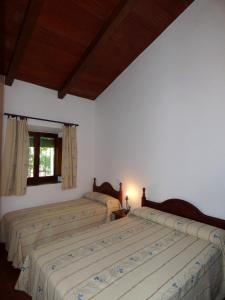 2 łóżka w sypialni z białymi ścianami i oknem w obiekcie Casa Rural El Poleo w mieście Villaviciosa de Córdoba