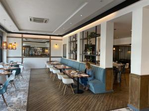 a woman sitting at a table in a restaurant at Gran Hotel Azul in Azul