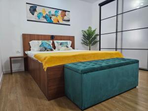 a bedroom with a large bed with a green ottoman at Confort Studio 2 City Center in Bucharest