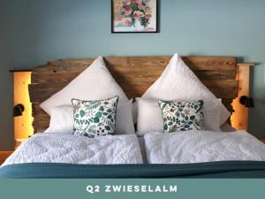 a bed with white sheets and pillows at Dachstein 7 in Gosau