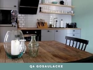 a wooden table with a glass vase and a candle on it at Dachstein 7 in Gosau