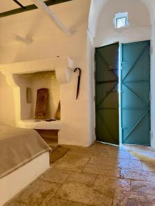 Una gran puerta verde en una habitación con una cama. en casanu, en Ostuni