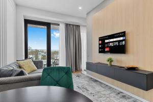 a living room with a couch and a flat screen tv at LAX Exquisite 1BR,1BATH -City Skyline Views in Bucharest