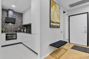 a kitchen with white cabinets and a black stool at LAX Exquisite 1BR,1BATH -City Skyline Views in Bucharest