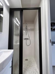 une salle de bain avec douche et lavabo dans l'établissement Urban Nest Palanga, à Palanga