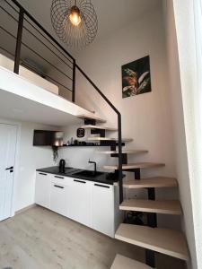 une cuisine avec des placards blancs et un escalier en colimaçon dans l'établissement Urban Nest Palanga, à Palanga