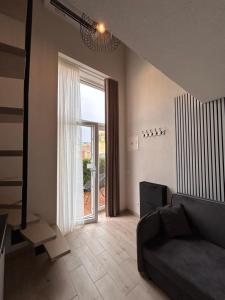 un salon avec un canapé et une grande fenêtre dans l'établissement Urban Nest Palanga, à Palanga 3 autres photos