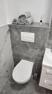 a bathroom with a white toilet and a sink at Vegas luxury apartment in Constanţa