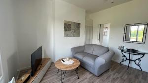 a living room with a couch and a table at Le Compiègnois in Compiègne