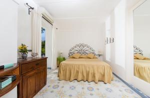 a bedroom with two beds and a dresser and a mirror at Il Giardino dell'Arte in Anacapri