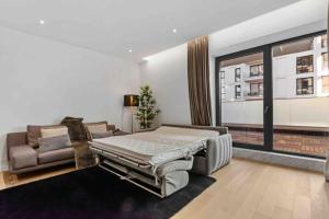 Un dormitorio con una cama y un sofá y una ventana. en Luxurious Vibe In the Business Center, City Views, en Bucarest