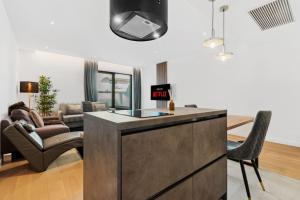 Una cocina y una sala de estar con un sofá y una mesa. en Luxurious Vibe In the Business Center, City Views, en Bucarest