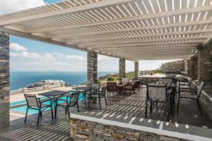 eine Terrasse mit Tischen und Stühlen und Meerblick in der Unterkunft Gerofinikas Boutique Hotel in Apollonia