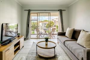 a living room with a couch and a table at Belina - Bougain Villas Estate View in Cape Town