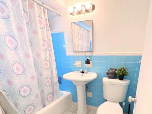 a bathroom with a toilet sink and a shower curtain at Southwinds Inn by The Gold Nests in Hollywood +156 photos