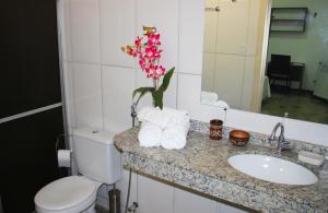 a bathroom with a sink and a toilet and a flower at Hotel Marajoara in Belém +75 photos