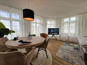 a living room with a table and a tv at Nr 3 Lichtdurchflutetes Apartment am Historischen Marktplatz 66 qm #Cosiness Company 23 in Schwerin